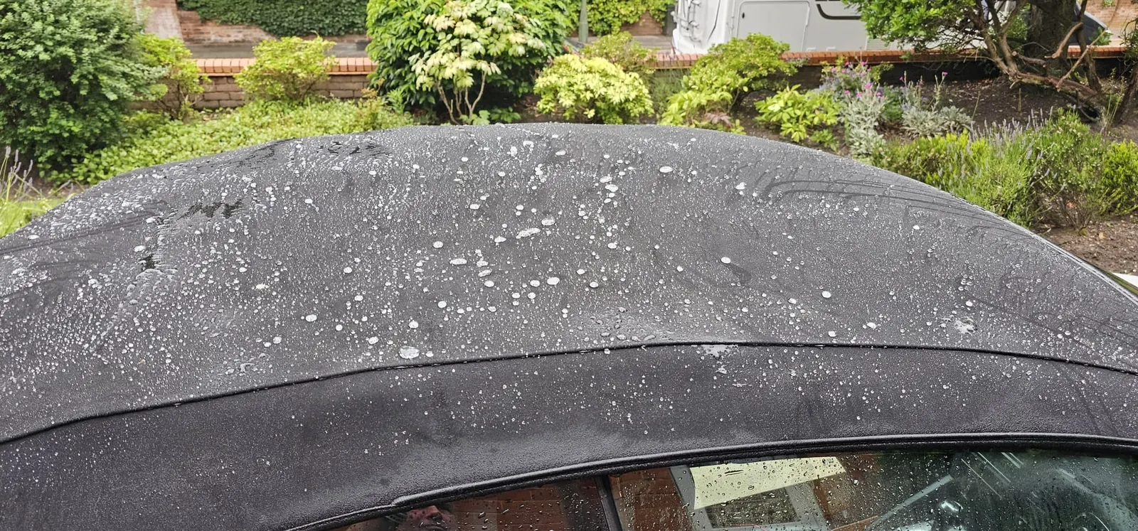 Water beading on a protected convertible soft-top roof after Platinum Car Cleaning fabric protection