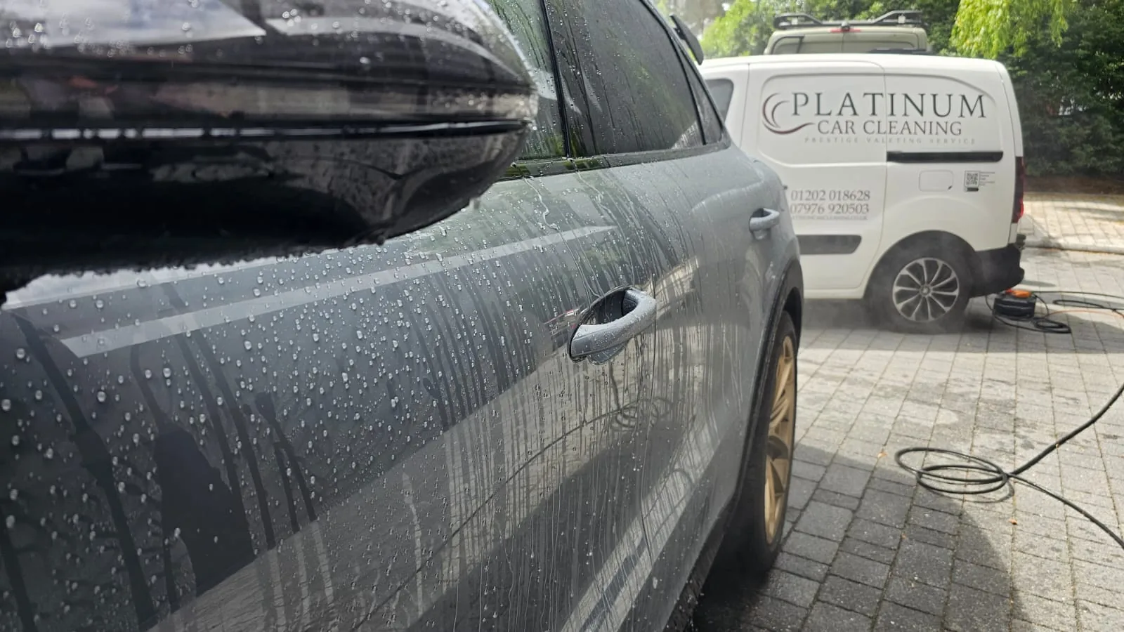 Water beading on a cleaned vehicle with Platinum Car Cleaning van nearby